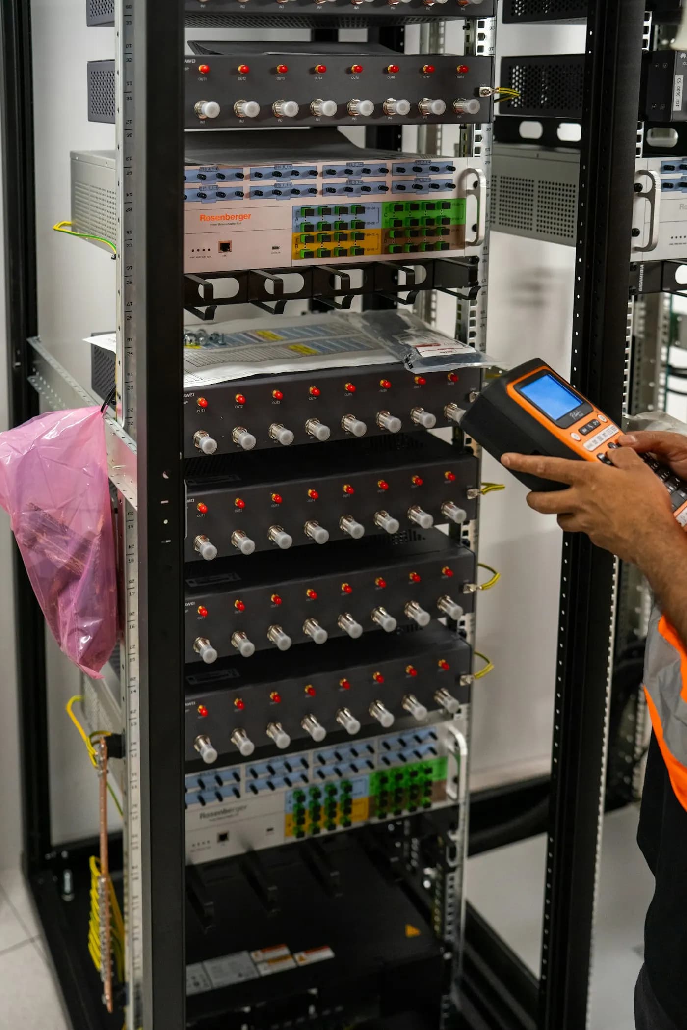 A technician testing cables in a network rack